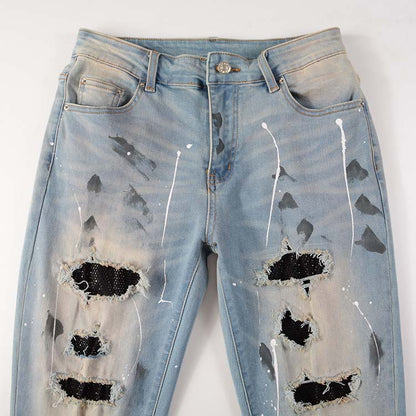 Jeans bleu déchire avec trace de peinture et surpiqûre noir