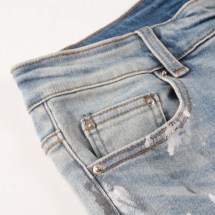 Jeans bleu déchire avec déchirure et éclat de peinture