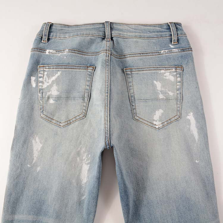 Jeans bleu déchire avec déchirure et éclat de peinture