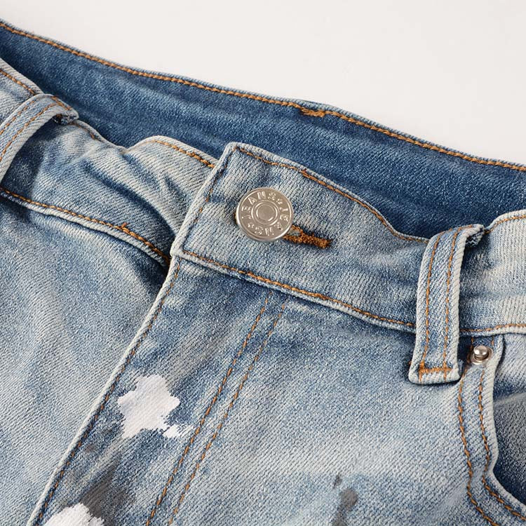 Jeans bleu déchire avec déchirure et éclat de peinture