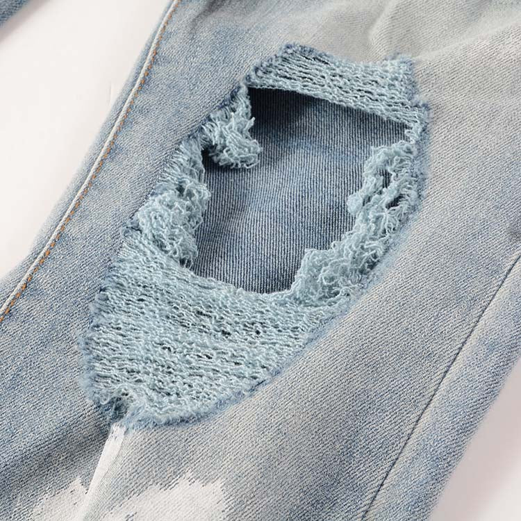 Jeans bleu déchire avec déchirure et éclat de peinture